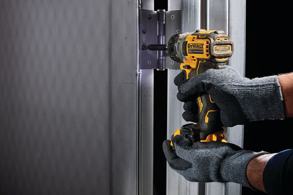 XTREME brushless cordless screwdriver fastening hinge between two metal surfaces.